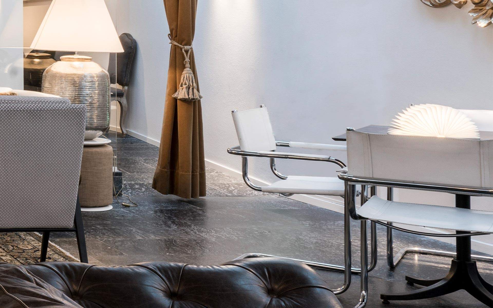 A relaxing lounge corner with glass table and metal chairs